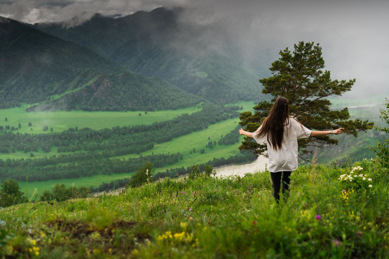 A woman stands amidst the scenic greenery of Chemal, Altai Republic, Russia.